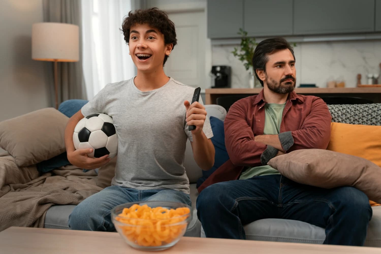 Two people reaching for the same TV remote
