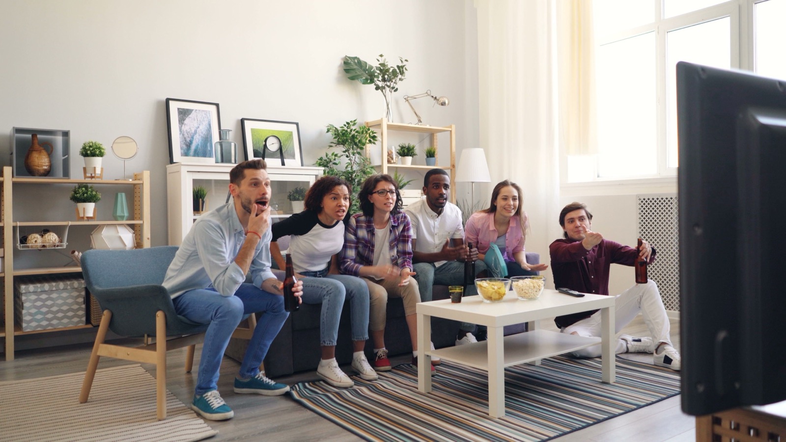 Group of people in a living room enjoying IPTV UK streaming on a flat screen TV