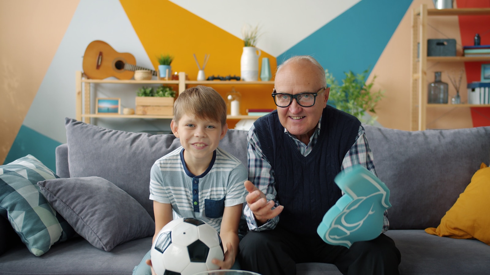 Grandfather and grandson watching soccer together on IPTV