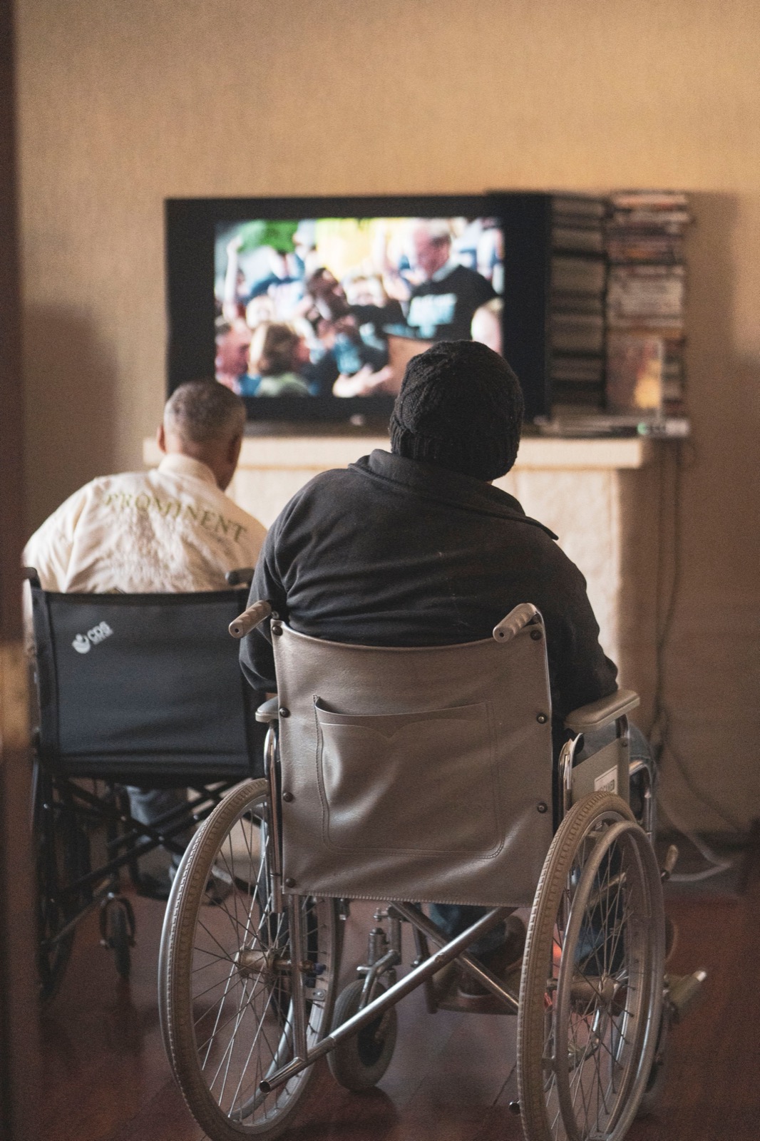 Two adults watching IPTV streaming on television at home using a premium IPTV service